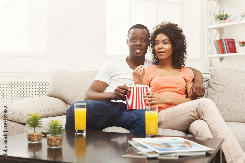 Happy african-american couple watching TV at home Happy african-american couple watching TV at home