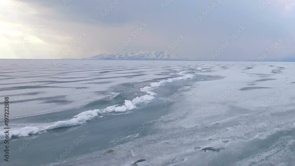 Flying over iced sea or lake by helicopter . Flying over iced sea or lake by helicopter .
