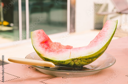 Fotografi Eaten watermelon, just the rind on a plate with a knife by side.