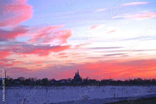 spring March evening pink decline sky nature in the country  in the distance orthodox church