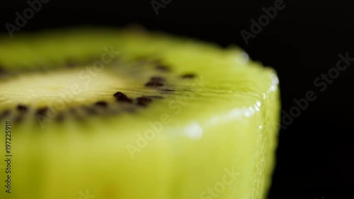 Macro shooting of a kiwi. A kiwi close up on a black background. Juicy green a kiwi on a black background. Fruit close up. Juicy Fruiti rotates photo