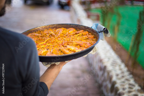 Man carrying a Paella. Spanish food.