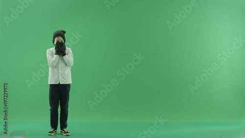 Little boy showing the forecast of cold and hot weather on the left side on the green screen