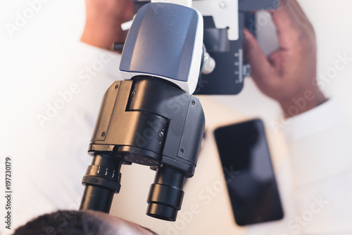 close up of man using microscope