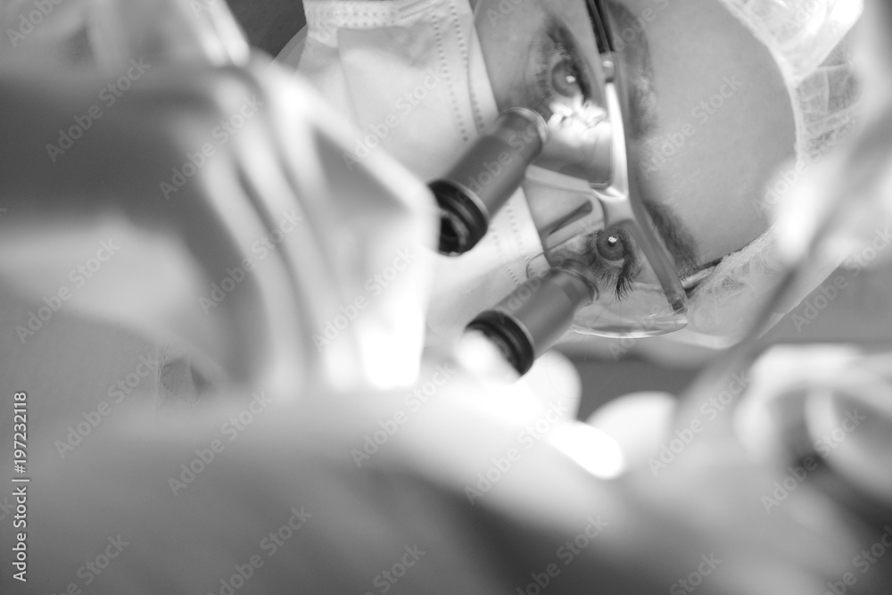 Female dentist in surgical uniform at the clinic while performing surgery for the patient Female dentist in surgical uniform at the clinic while performing surgery for the patient