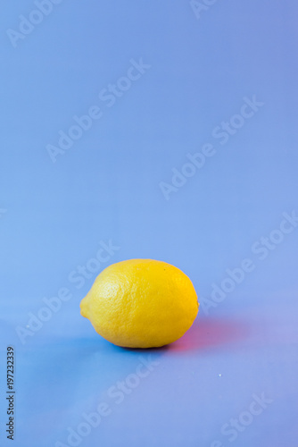 Fresh lemon on a violet blurred background photo