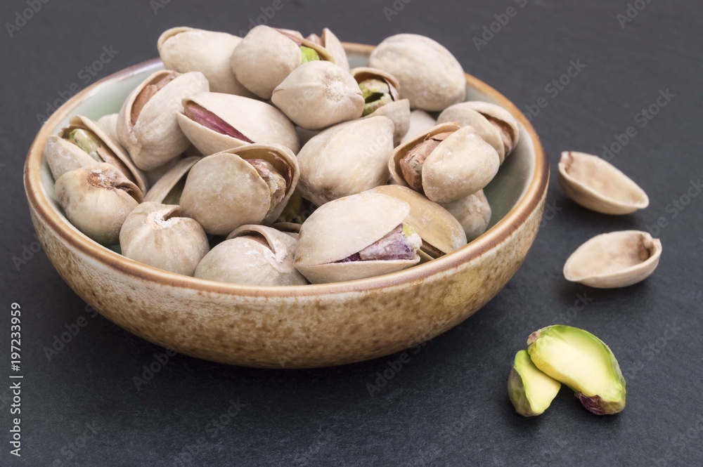 pistachios on black background in a bowl