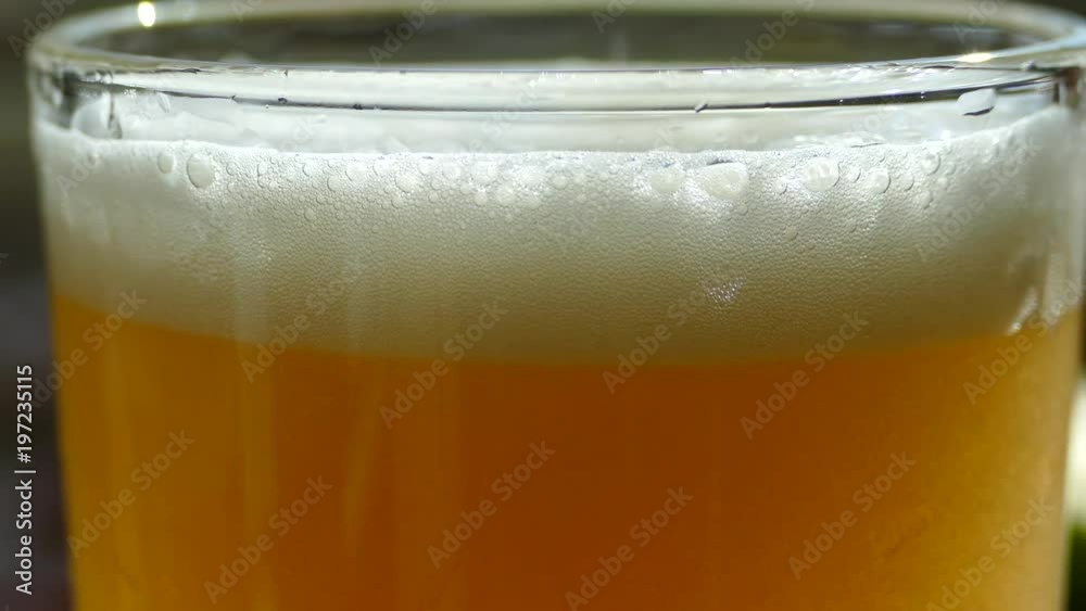 Beer is poured into a glass. Beautiful bubbles fly in a glass of frothy beer. Beer is poured into a glass. Beautiful bubbles fly in a glass of frothy beer.