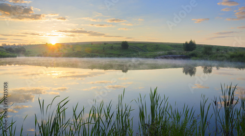 Fototapeta Naklejka Na Ścianę i Meble -  . Sunny summer morning.Foggy landscape with river.Beautiful clouds in sky.Fog over the water.Warm sunlight at sunrise.River Krasivaya in Tula region,Russia. 