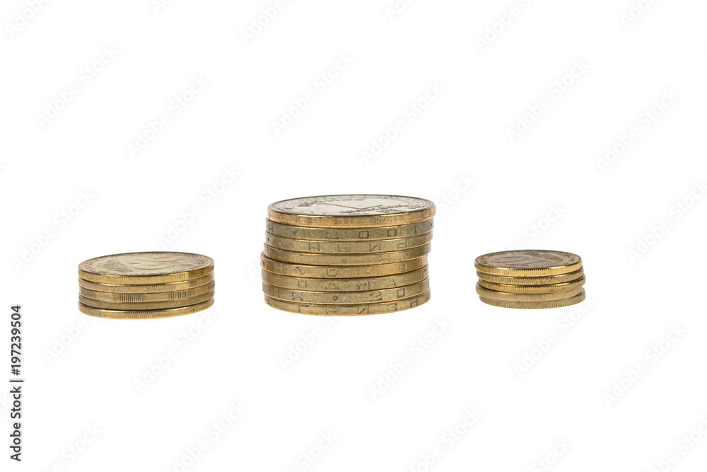 coins of yellow metal, of different denominations are stacked in columns on a white background coins of yellow metal, of different denominations are stacked in columns on a white background