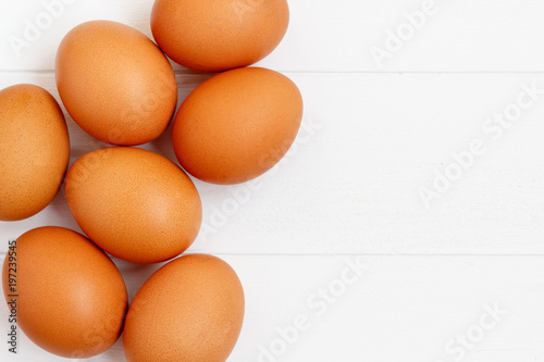 fresh or raw brown eggs on white wooden background, top view, flat lay with copy space, food ingredient