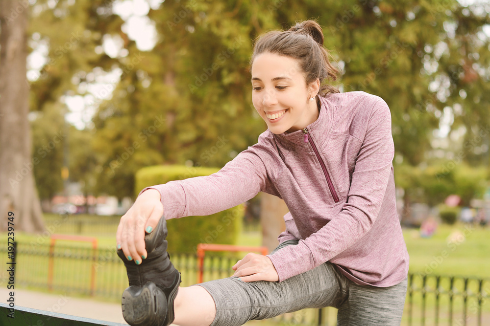 Obraz premium Portrair of young beautiful woman doing exercise at park