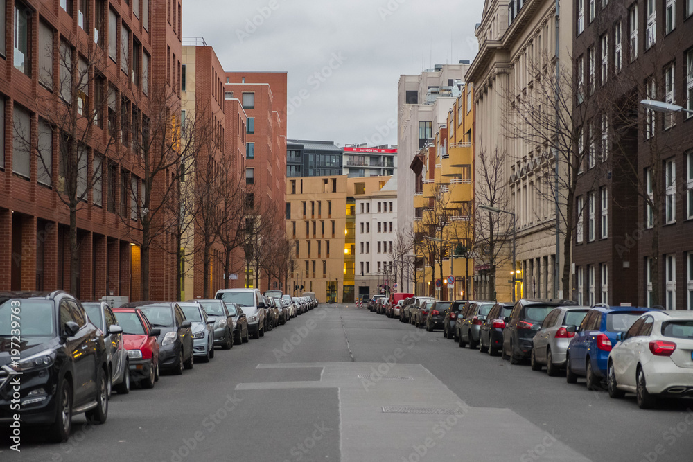 Berlin. Germany. A city street with parked cars on either side of the sidewalk