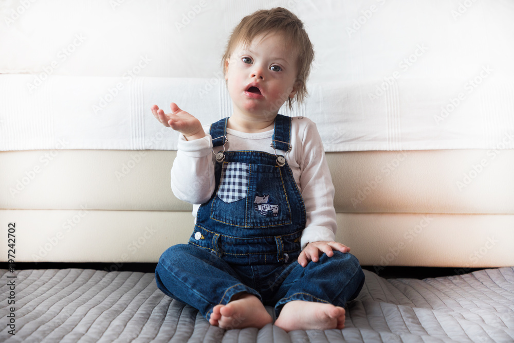 Portrait of cute baby boy with Down syndrome in home living room Portrait of cute baby boy with Down syndrome in home living room