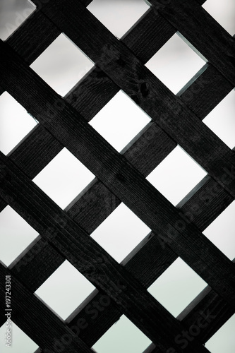Geometric background with squares. Black wooden grille