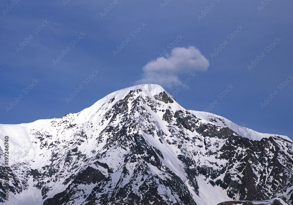 Snow-capped mountain with single cloud on top