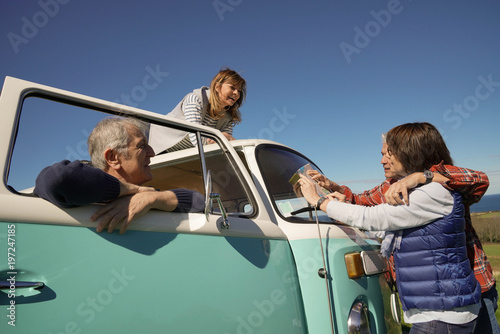 Senior people on a road trip with camper van reading map