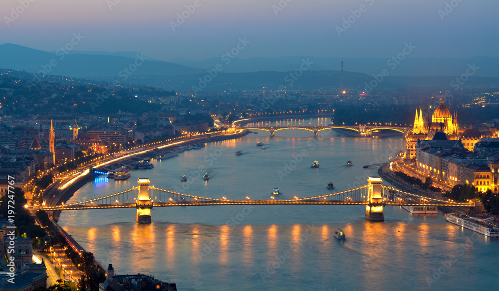Danube river night view with lot of floating boats, highlighted Chain bridge, Hungarian Parliament building