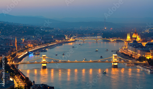Danube river night view with lot of floating boats, highlighted Chain bridge, Hungarian Parliament building