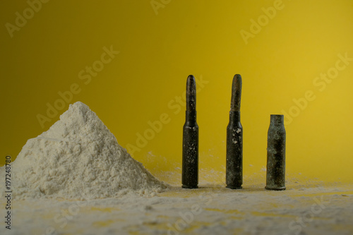 Cocaine and bullets in the yellow background photo