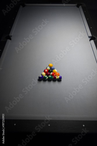 A rack of 8 ball on a black and white billiard table, for a tournament.