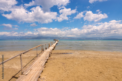 Fototapeta Naklejka Na Ścianę i Meble -  Wooden pier on sandy Apraos beach near Kassiopi town on Corfu island. Greece.