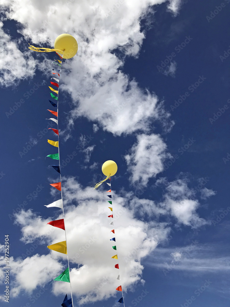 Zwei gelbe Ballons vor blauem Wolkenhimmel