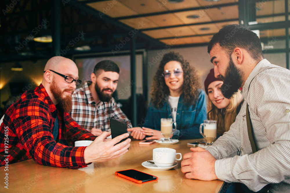 Friends communicate in cafe with mobile phone. Friends communicate in cafe with mobile phone.
