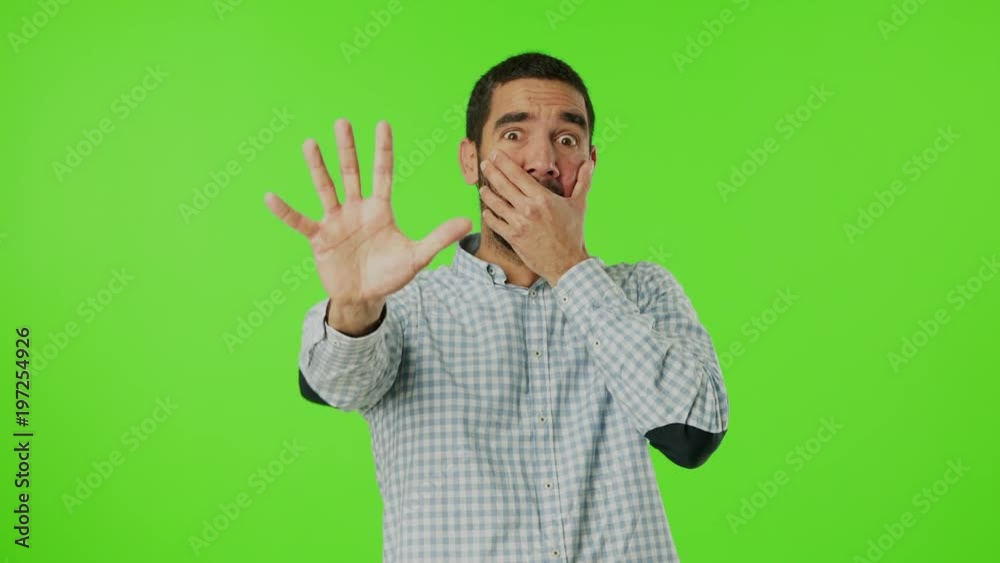 Scared young man against green background Scared young man against green background