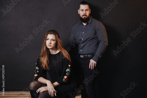 Stylish Fashion couple over black backgroung in trendy casual look. Fashion black dress and shirt in small dot.