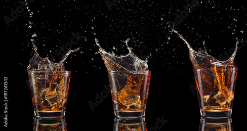 set of whiskey shots with splash isolated on black background photo