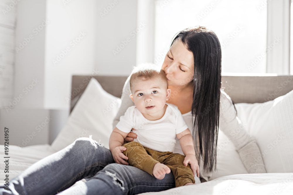 Mother with a baby on bed at home Mother with a baby on bed at home