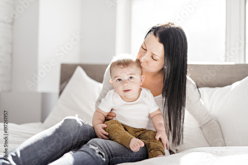 Mother with a baby on bed at home