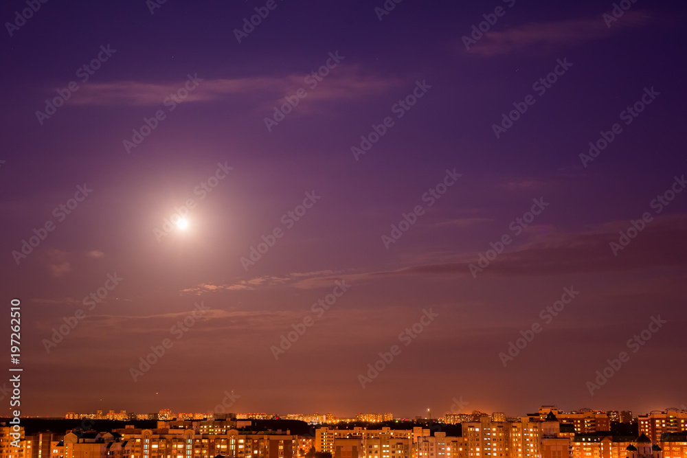 The moon shines over the city