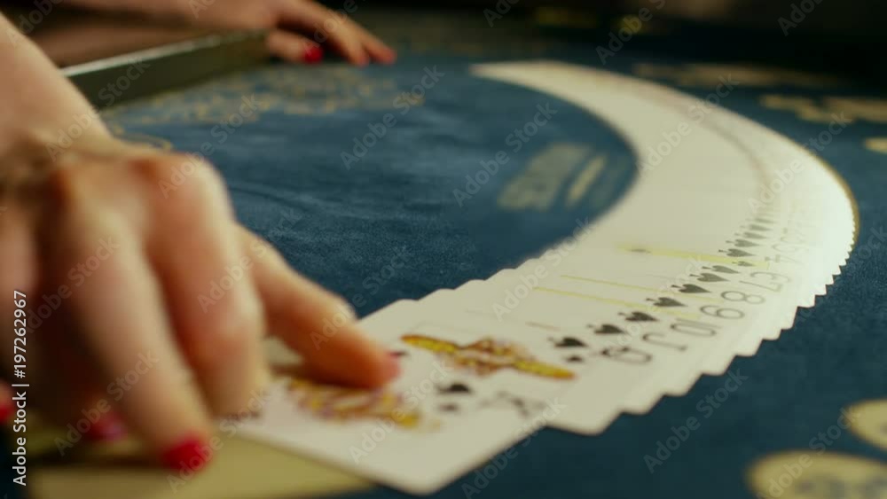 Casino croupier girl shuffles the poker cards and performing trick with cards. Casino croupier girl shuffles the poker cards and performing trick with cards.