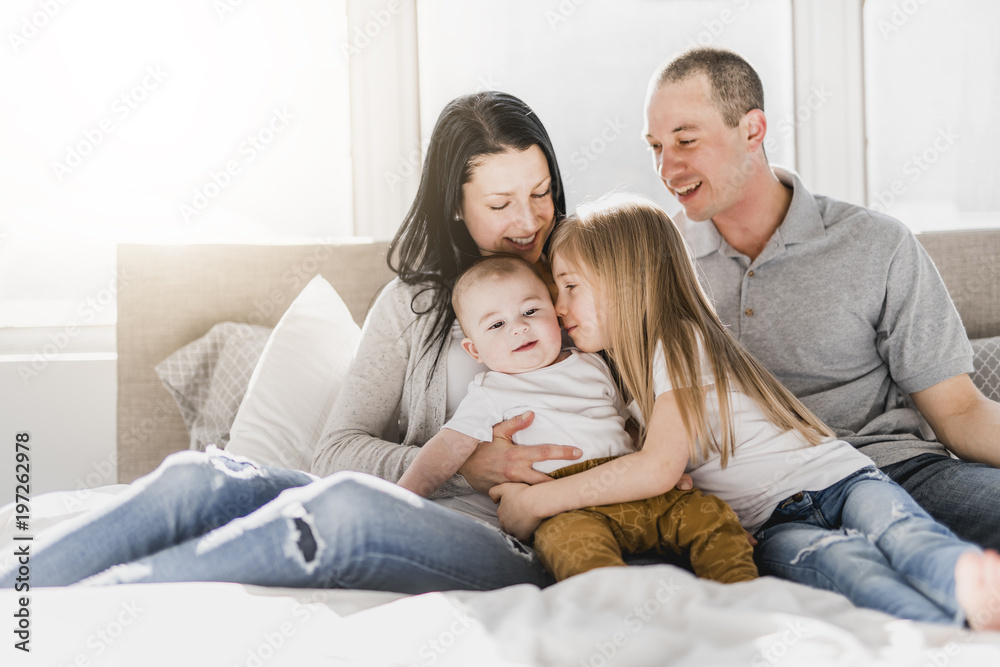 happy family on white bed in the bedroom happy family on white bed in the bedroom