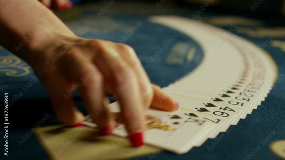 Casino: Dealer woman shuffles the poker cards and performing trick with cards. Shot on RED EPIC DRAGON Cinema Camera in slow motion.