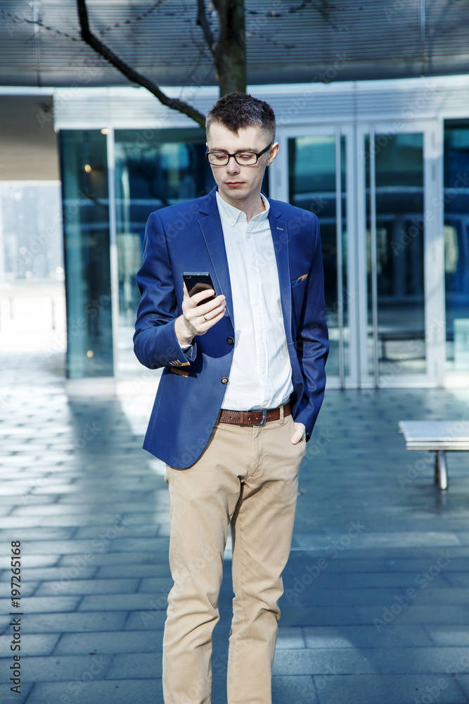 Business man. A man with a book and a laptop. The guy speaks through the phone on the street. The guy in the glasses makes notes in the notebook Business man. A man with a book and a laptop. The guy speaks through the phone on the street. The guy in the glasses makes notes in the notebook