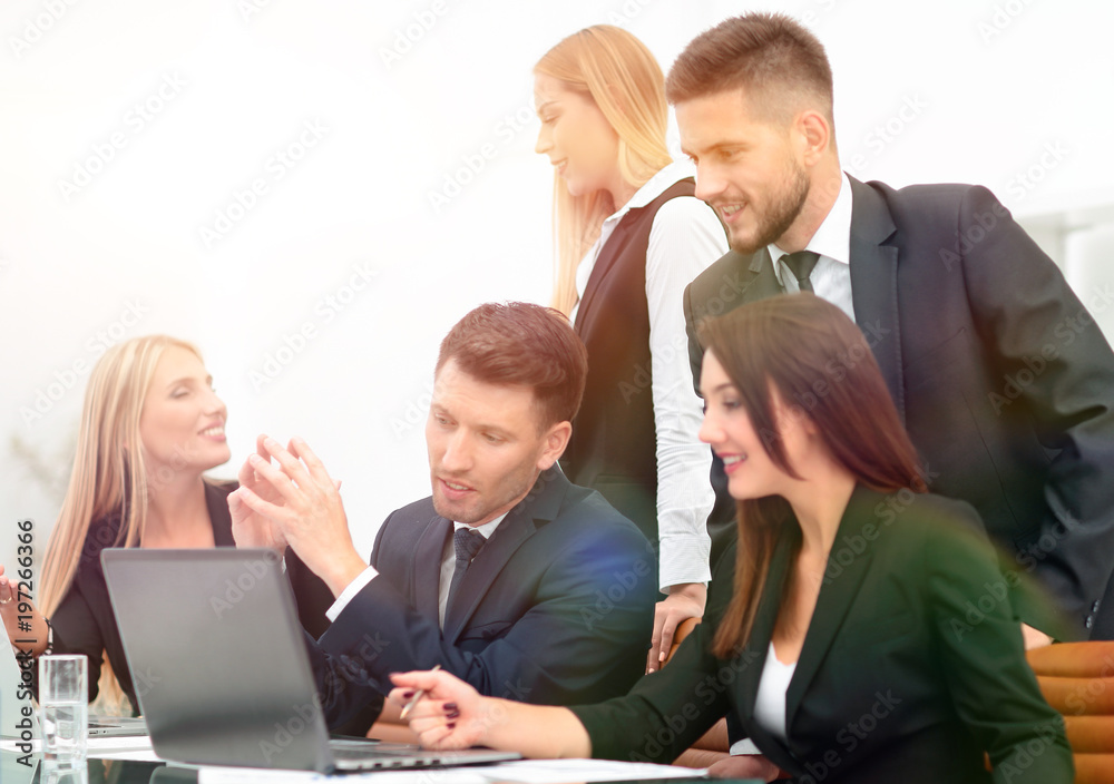 business team discussing new information , standing in front of the open laptop business team discussing new information , standing in front of the open laptop