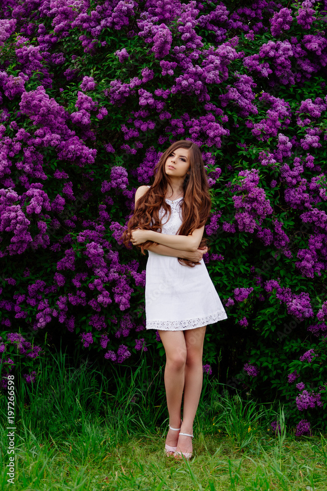 Happy beautiful young woman with long hair in a blooming spring Park, the charming girl in a white dress with bright flowering trees, the girl on the background of flowering gardens Happy beautiful young woman with long hair in a blooming spring Park, the charming girl in a white dress with bright flowering trees, the girl on the background of flowering gardens