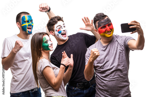 Group of people supporters fans of national teams painted flag face of Germany, Mexico, Korea Republic, Sweden take selfie from phone. Fans emotions.