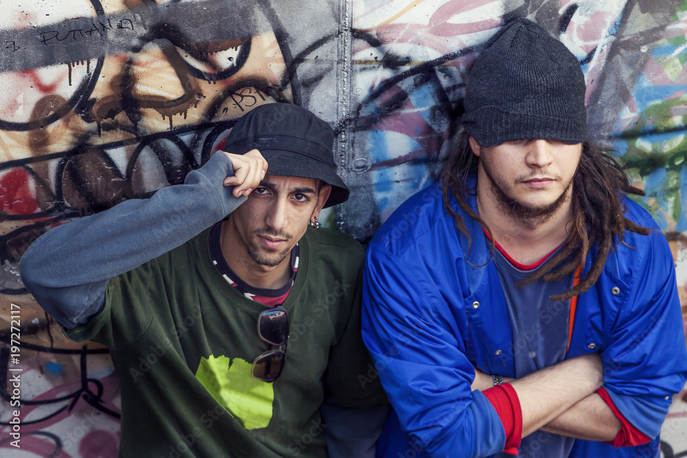 two rap singers in a subway with graffiti in the background two rap singers in a subway with graffiti in the background