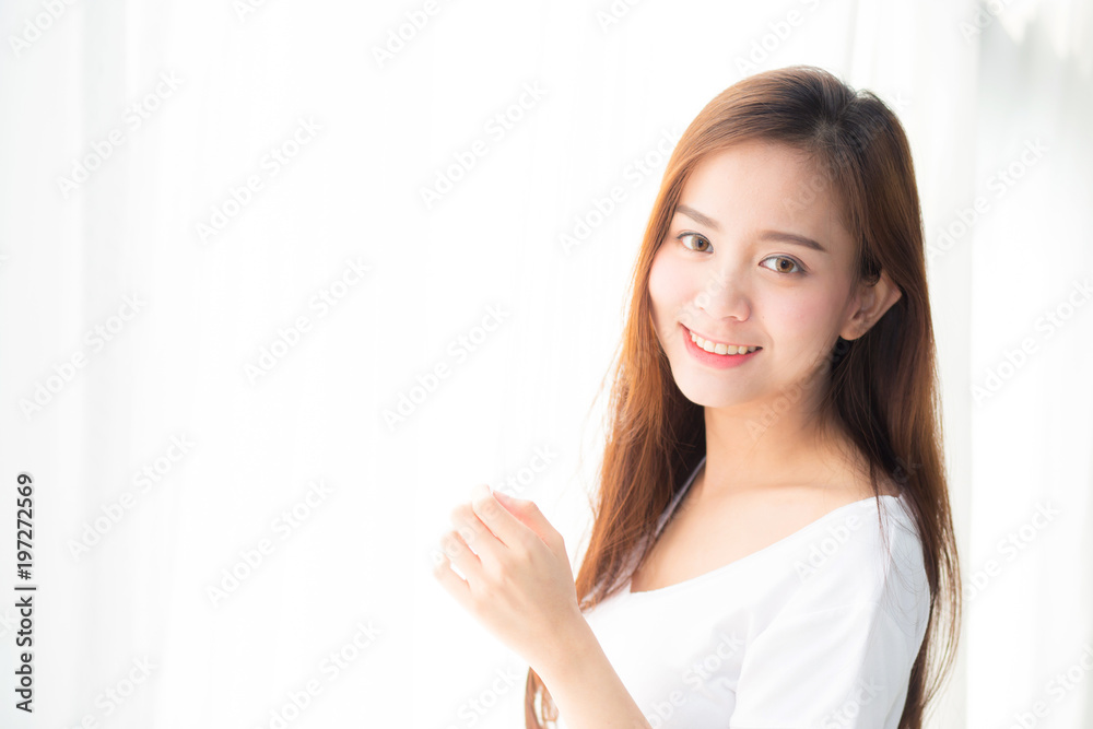 Beautiful young asian woman standing the window and smile while wake up with sunrise at morning, lifestyle and relax concept. Beautiful young asian woman standing the window and smile while wake up with sunrise at morning, lifestyle and relax concept.