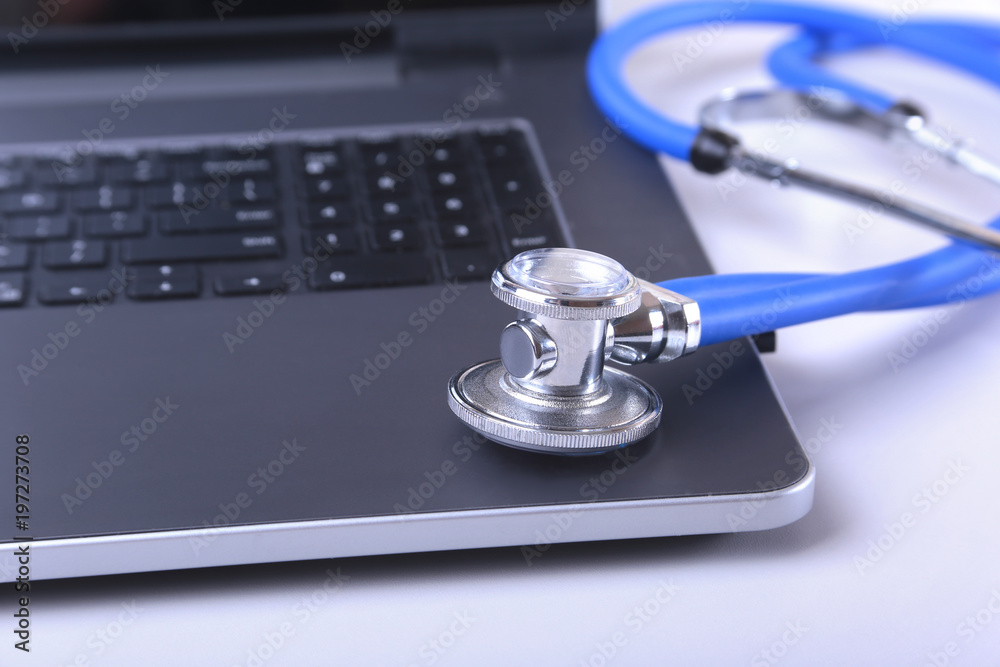 Workplace of doctor with laptop, stethoscope, RX prescription, glasses and notebook on white table. Copy space. Workplace of doctor with laptop, stethoscope, RX prescription, glasses and notebook on white table. Copy space.