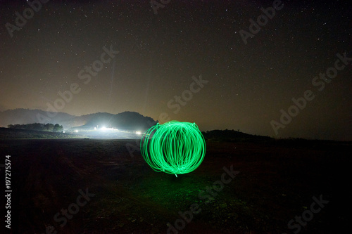 green light ball at night with many stars