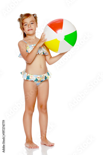 Little girl in a swimsuit with a ball