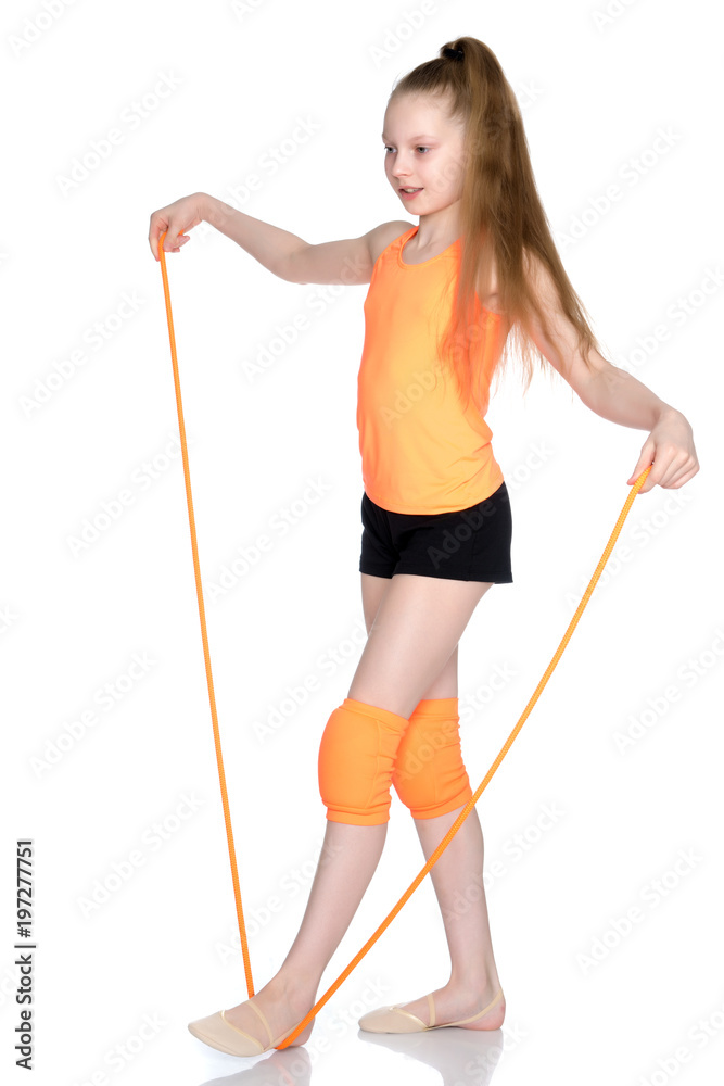 A girl gymnast performs exercises with a skipping rope. A girl gymnast performs exercises with a skipping rope.