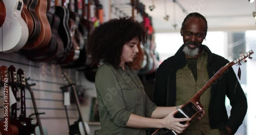 Small business owner helping customer in a guitar store