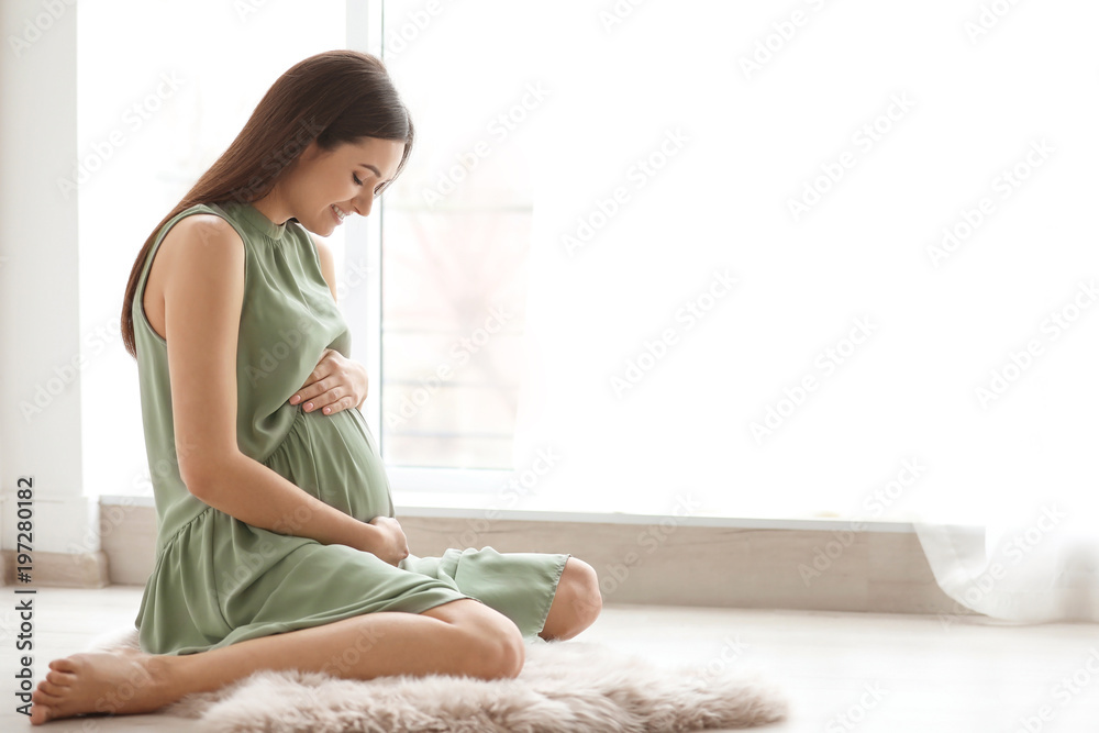 Εκτύπωση καμβά Young pregnant woman sitting on floor near window at home