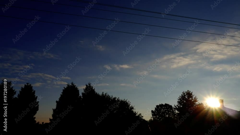 Countryside sun dusk time lapse, rays behind trees, no clouds Countryside sun dusk time lapse, rays behind trees, no clouds